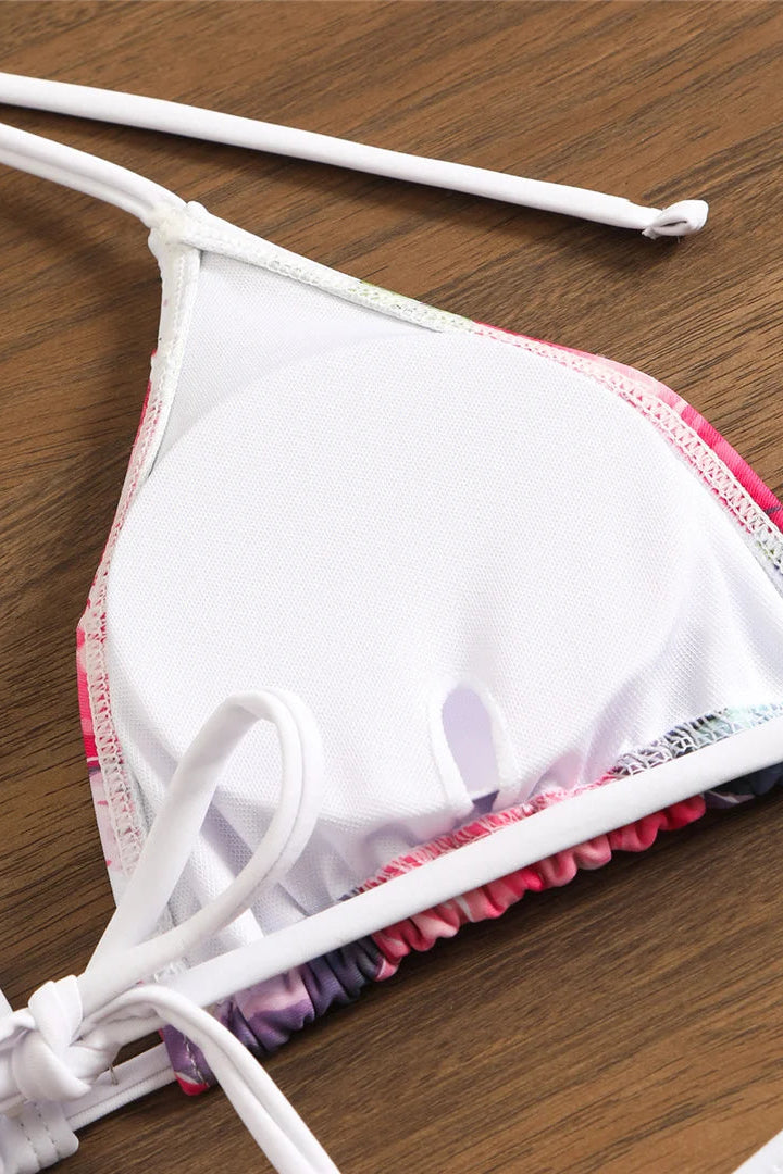 White bikini top with colorful trim on a wooden surface