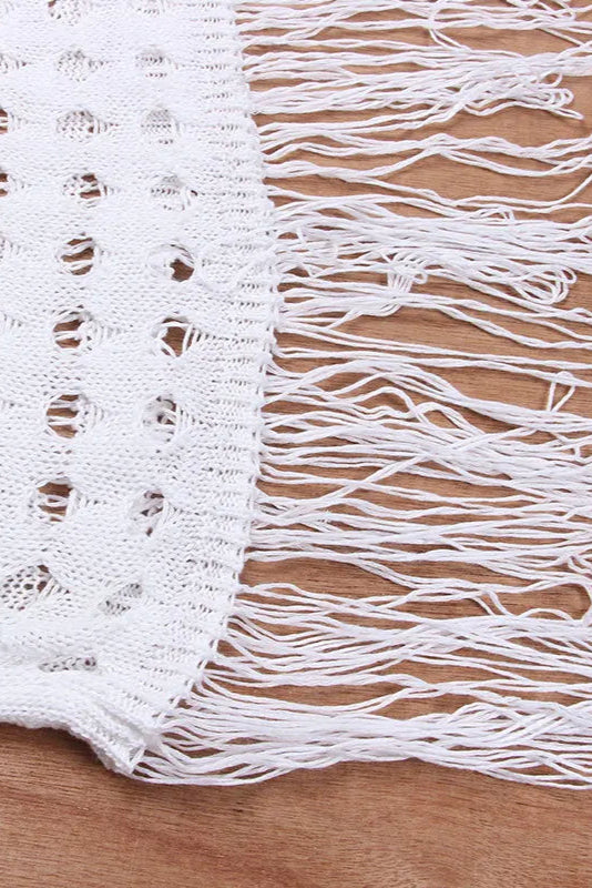 White lace fabric with fringe on a wooden surface
