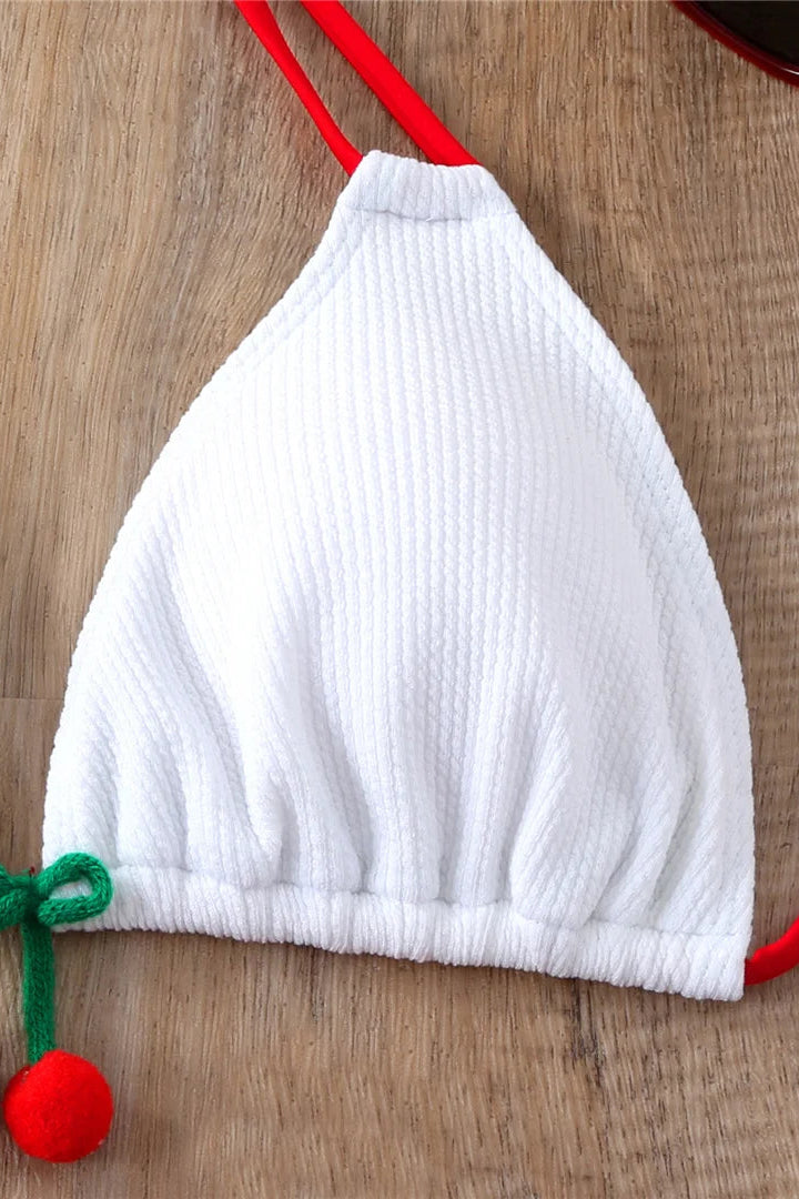 White ribbed bikini top with red straps on a wooden surface