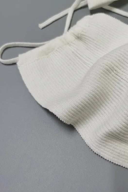 White ribbed knit top on a gray background