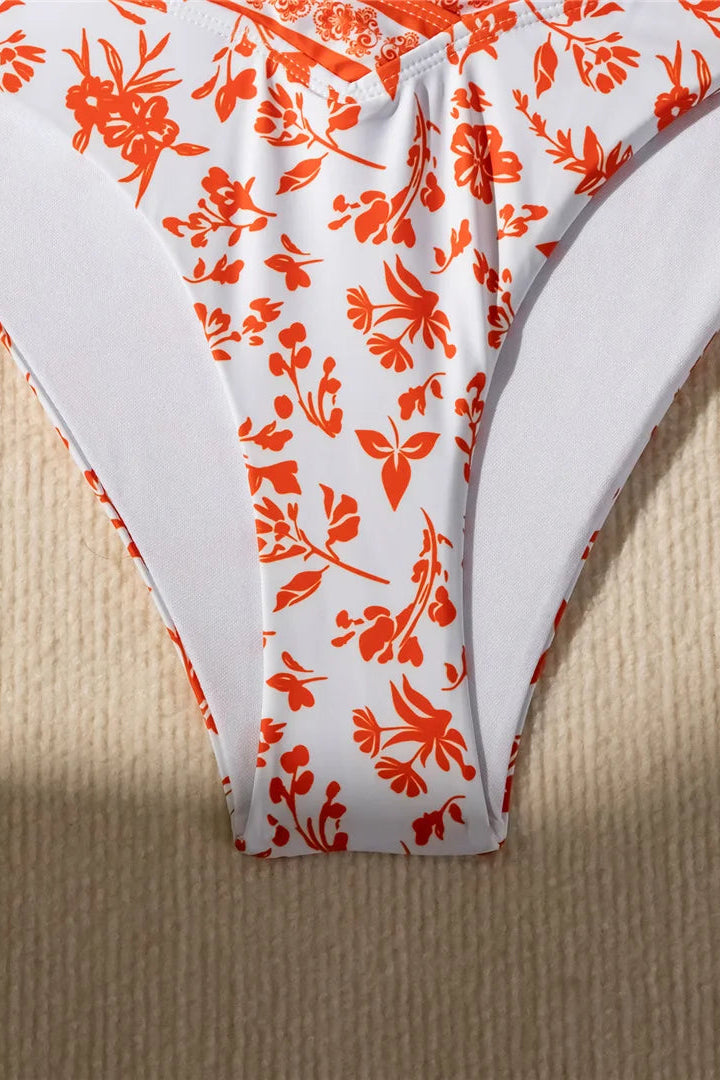 White underwear with orange floral pattern on a beige surface