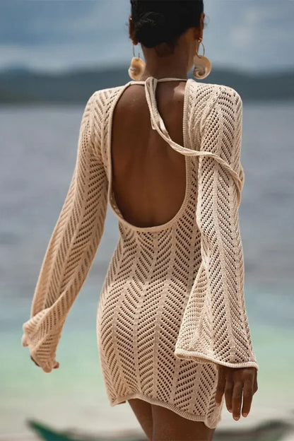 Woman wearing a beige crochet backless cover up by the ocean