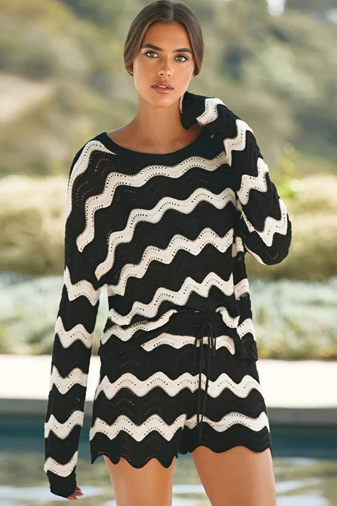 Woman wearing a black and white striped beach cover up by a pool