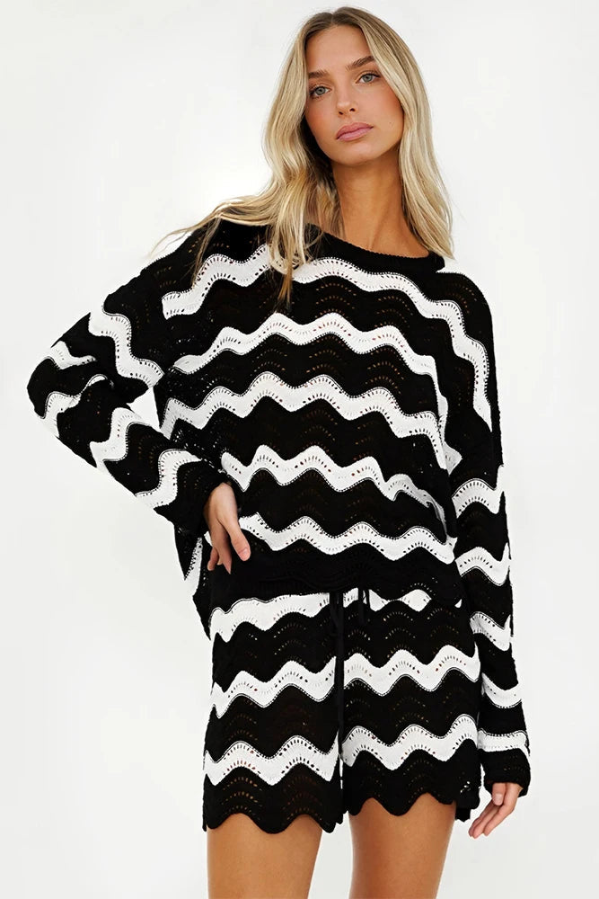 Woman wearing a black and white striped beach cover up on a white background