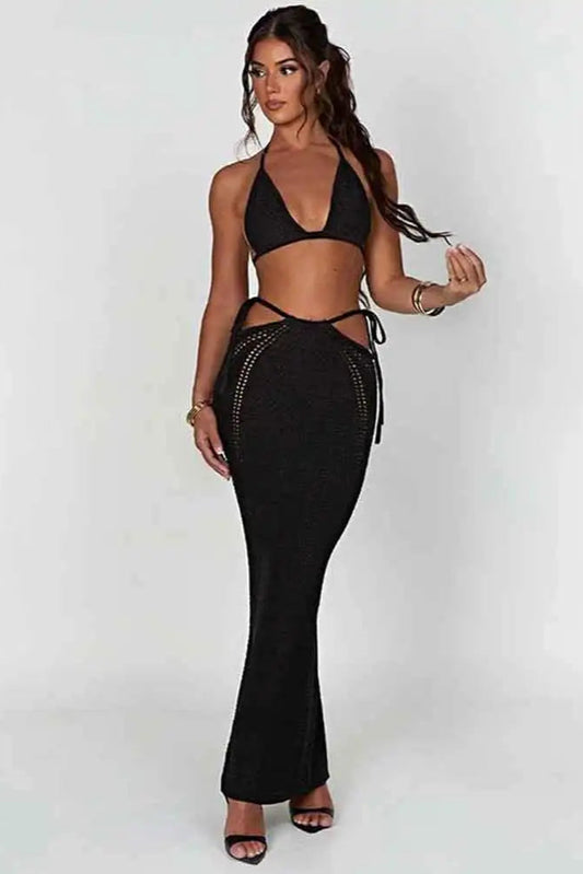Woman wearing a black beach outfit with cut-out details on a white background