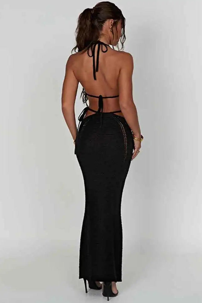 Woman wearing a black halter neck 2 piece beach wear set with cut-out sides on a white background