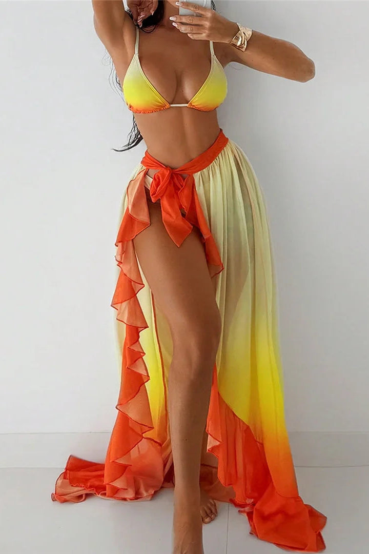 Woman wearing a colorful bikini with an orange and yellow gradient skirt on a white background