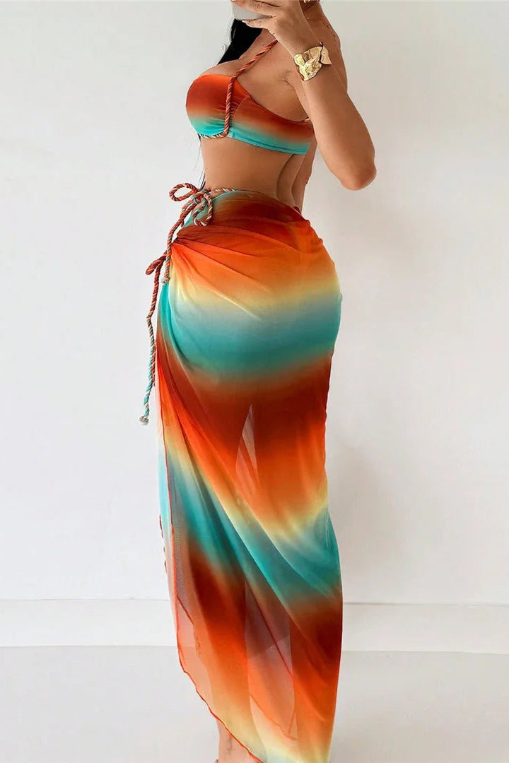 Woman wearing a colorful tie-dye bikini set with sarong cover up with a white background