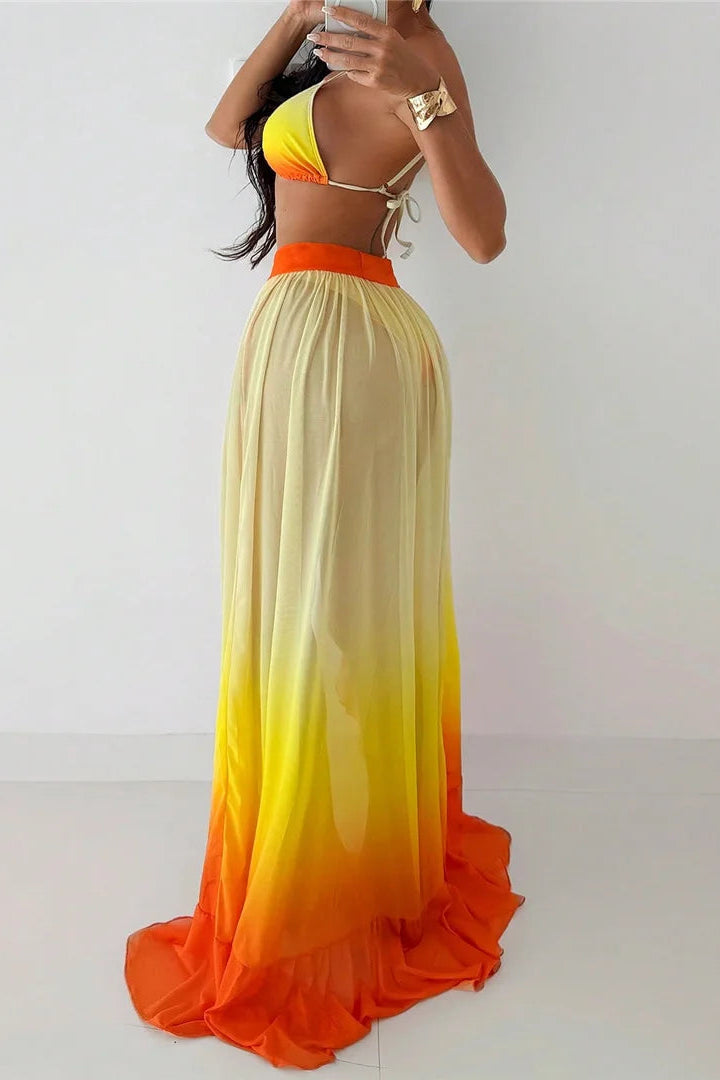 Woman wearing a colorful two-piece outfit with a gradient from yellow to orange on a plain background