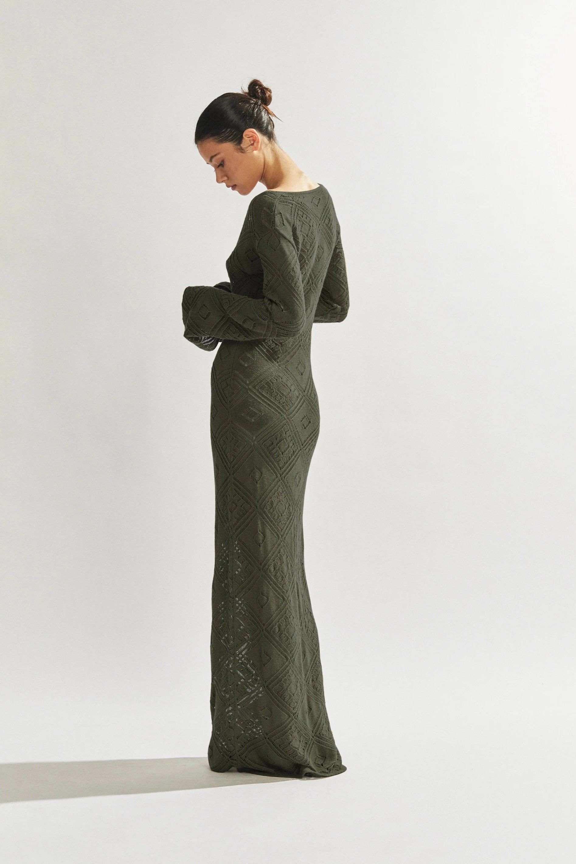 Woman wearing a green long dress against a white background