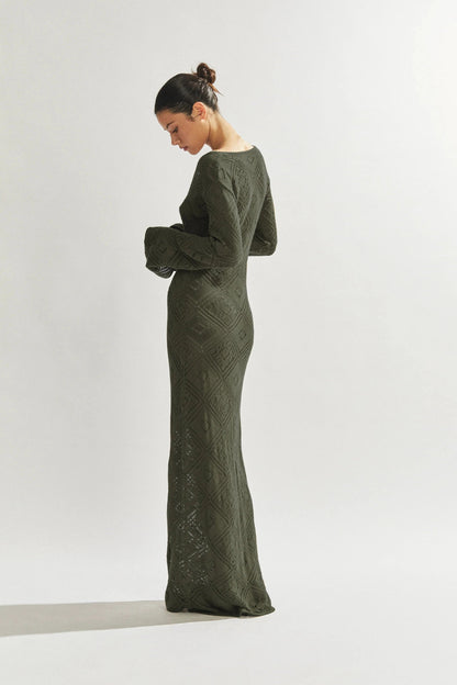 Woman wearing a green long dress against a white background