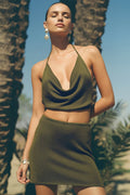 Woman wearing a green outfit with palm trees in the background