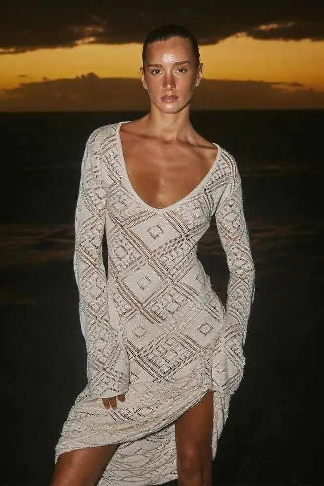 Woman wearing a patterned dress against a sunset sky