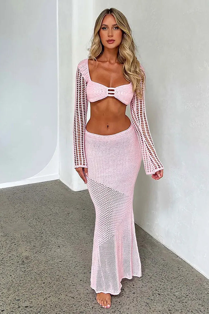 Woman wearing a pink crochet outfit against a white background