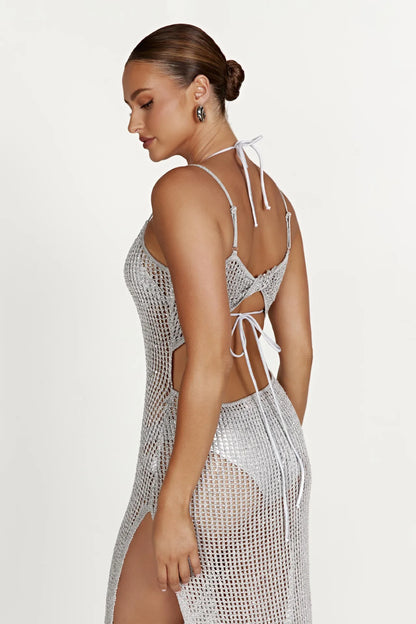 Woman wearing a silver crochet cover-up against a white background