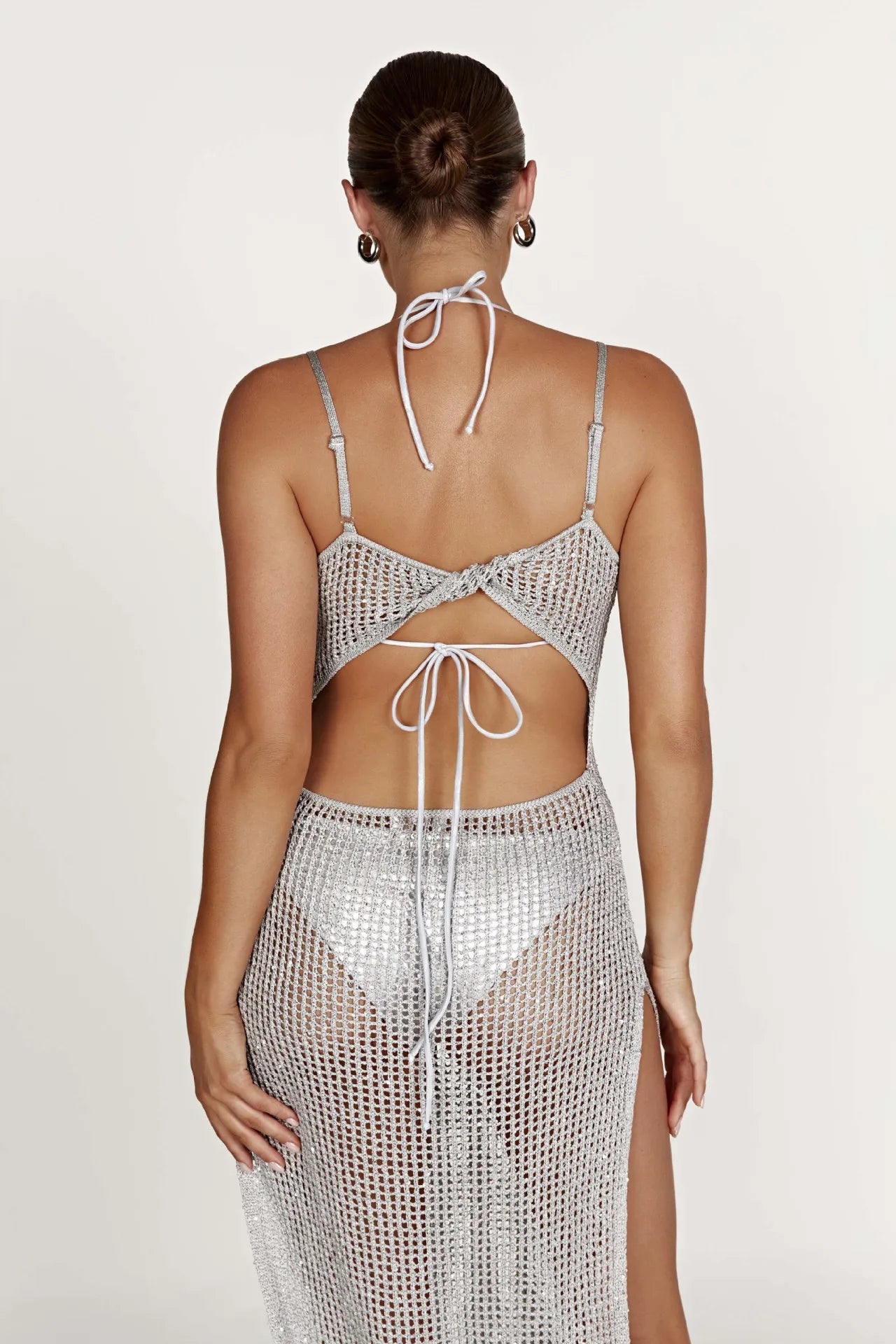 Woman wearing a swimsuit cover up on a white background