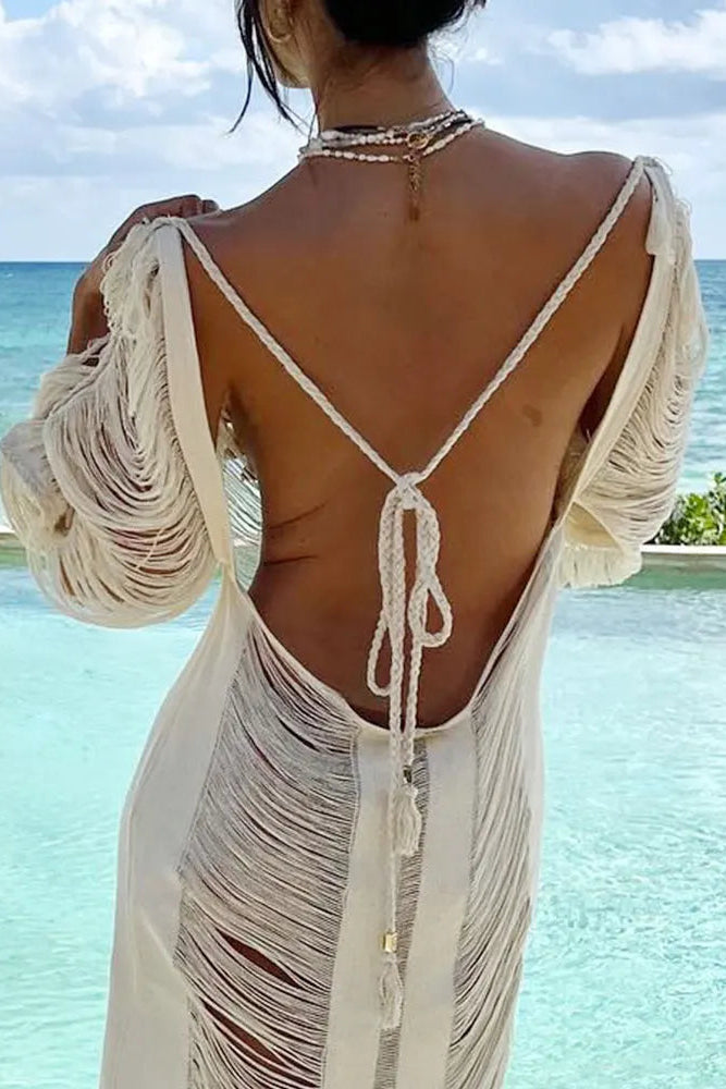 Woman wearing a white beach cover-up with a scenic ocean view in the background