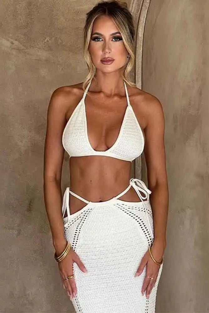 Woman wearing a white bikini and skirt against a neutral background