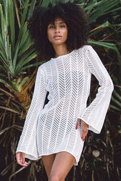 Woman wearing a white crochet cover-up against a tropical plant background