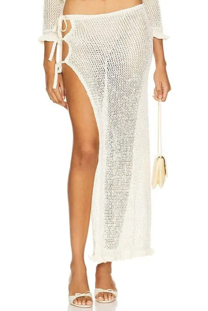 Woman wearing a white crochet cover-up on a white background