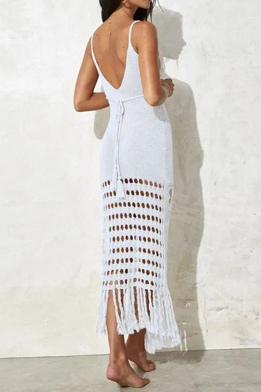 Woman wearing a white crochet dress against a light background