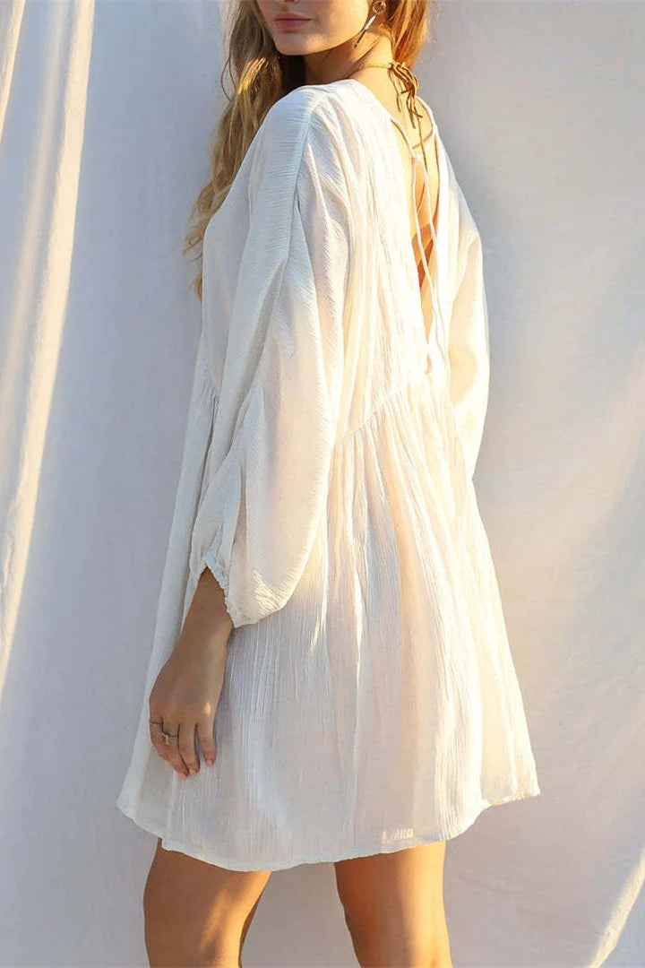 Woman wearing a white dress against a plain background