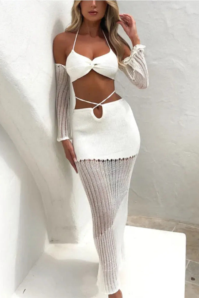 Woman wearing a white outfit with sheer sleeves against a light background