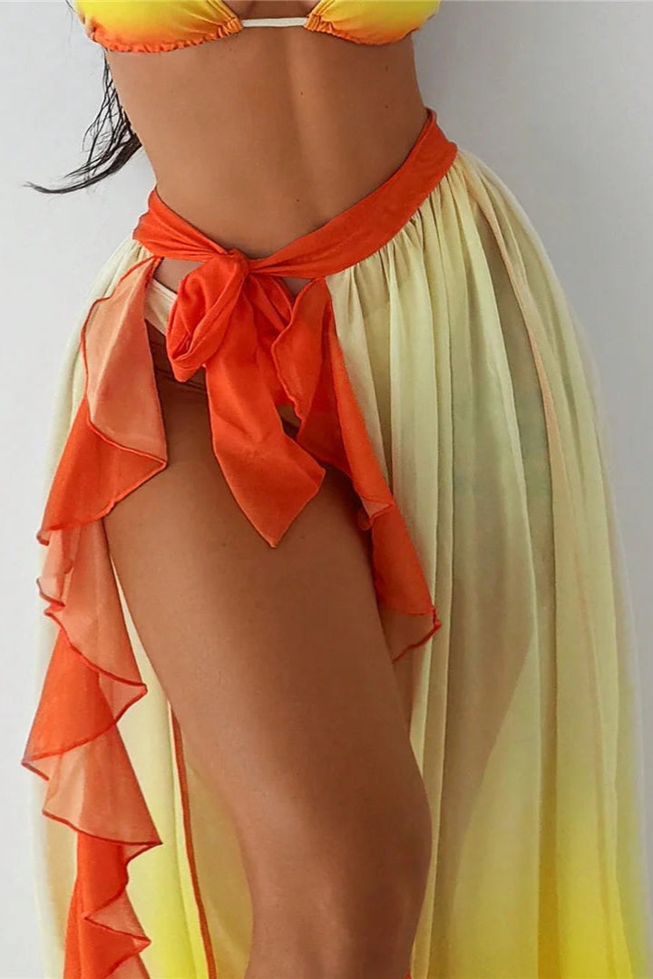 Woman wearing a yellow and orange bikini with a matching cover-up on a plain background