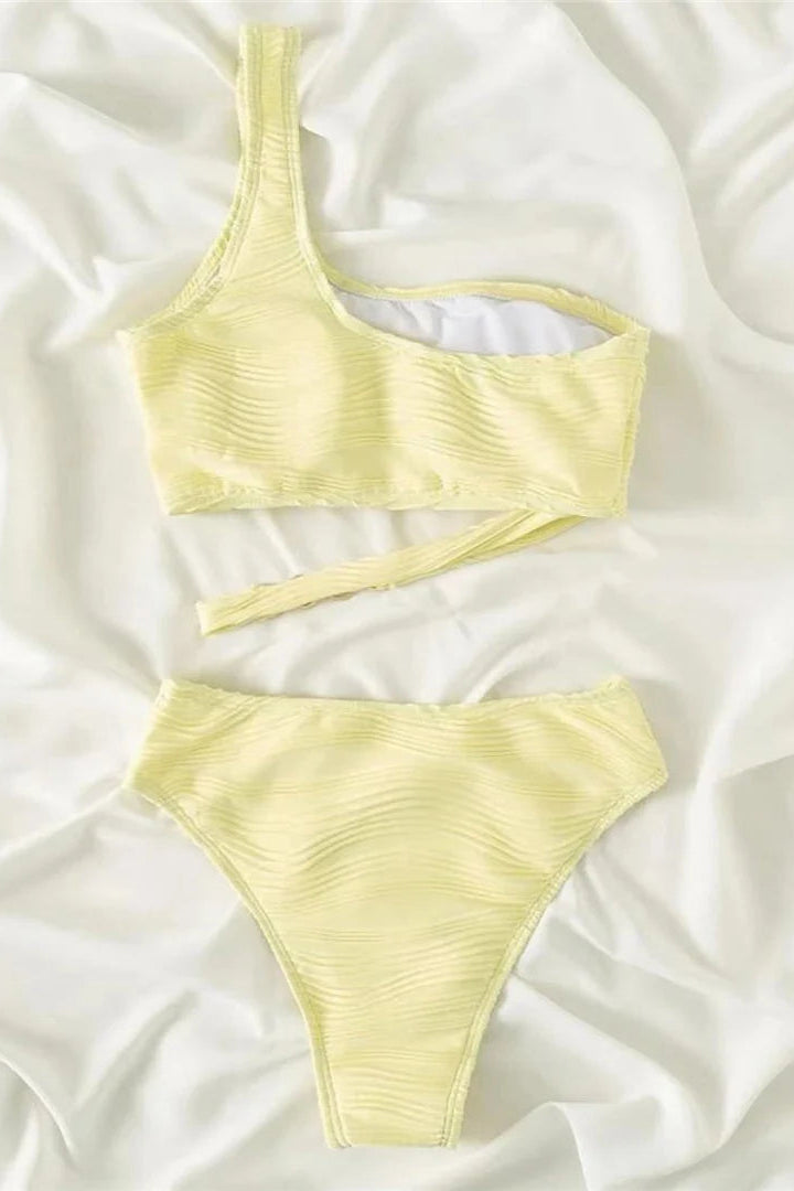 Yellow bikini set on a white fabric background