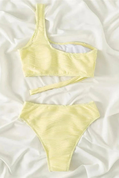 Yellow bikini set on a white fabric background