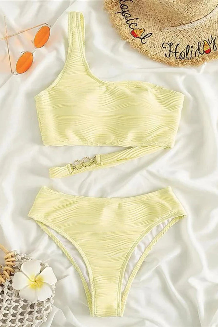 Yellow bikini set with a straw hat and sunglasses on a white background