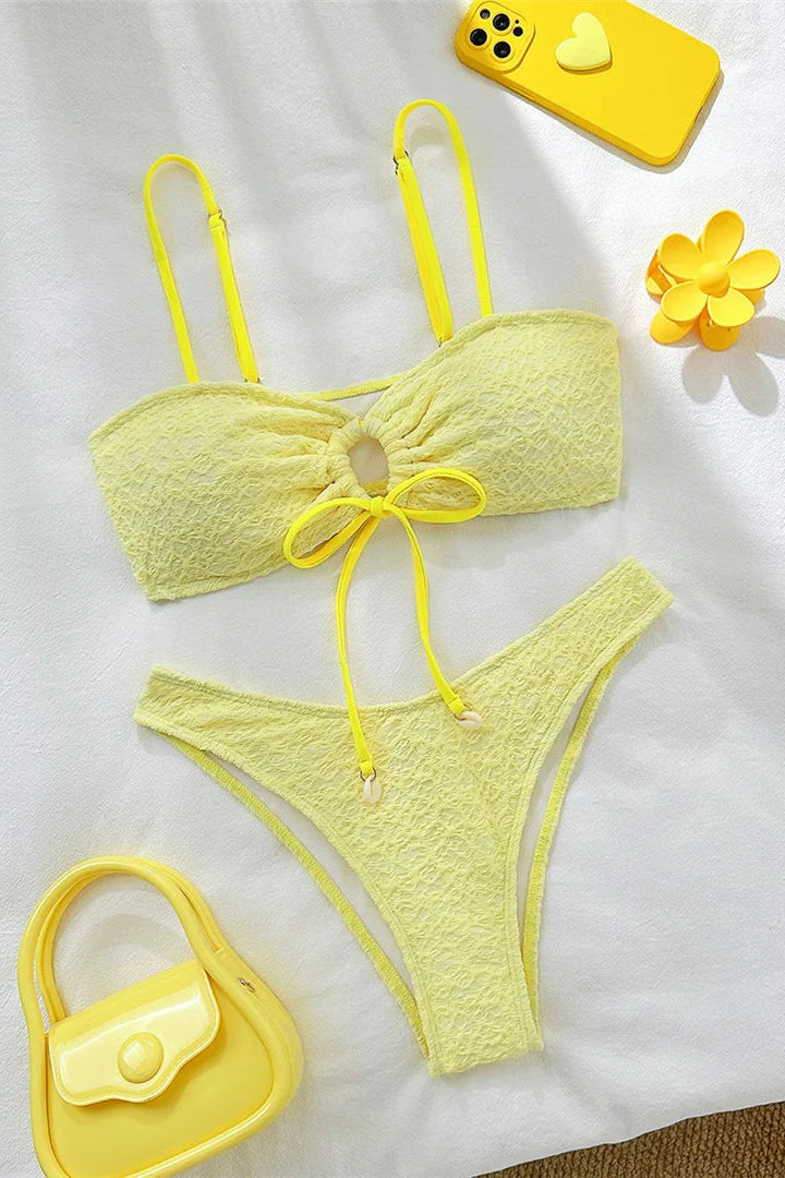 Yellow bikini set with matching accessories on a white background