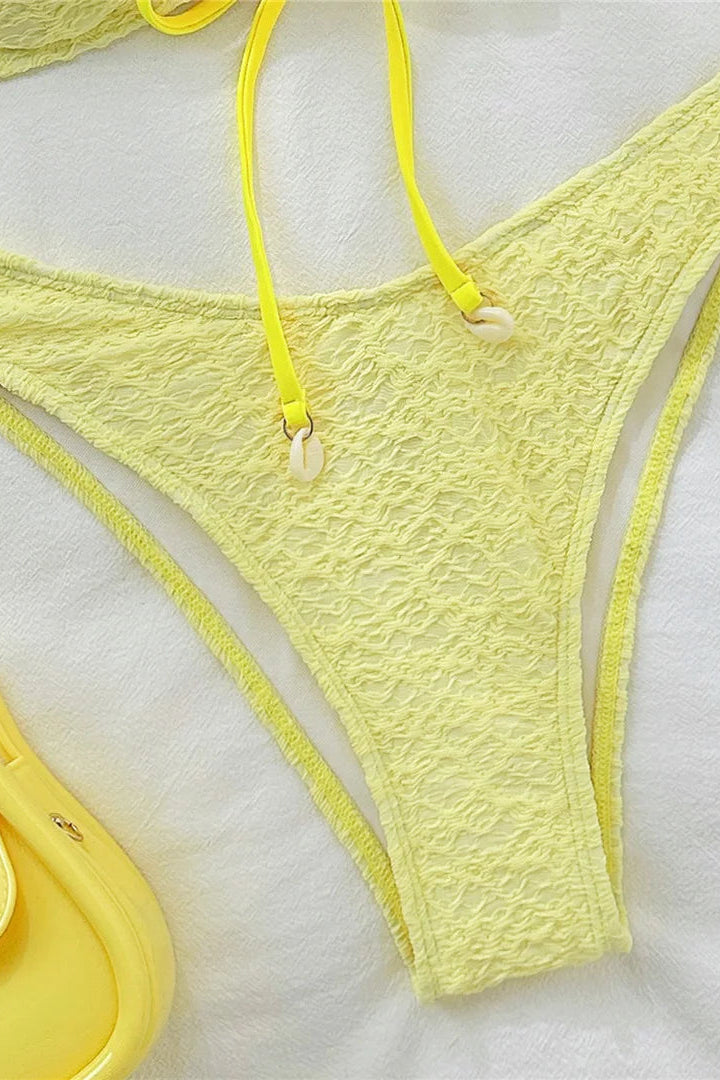 Yellow lace bikini bottom on a white background